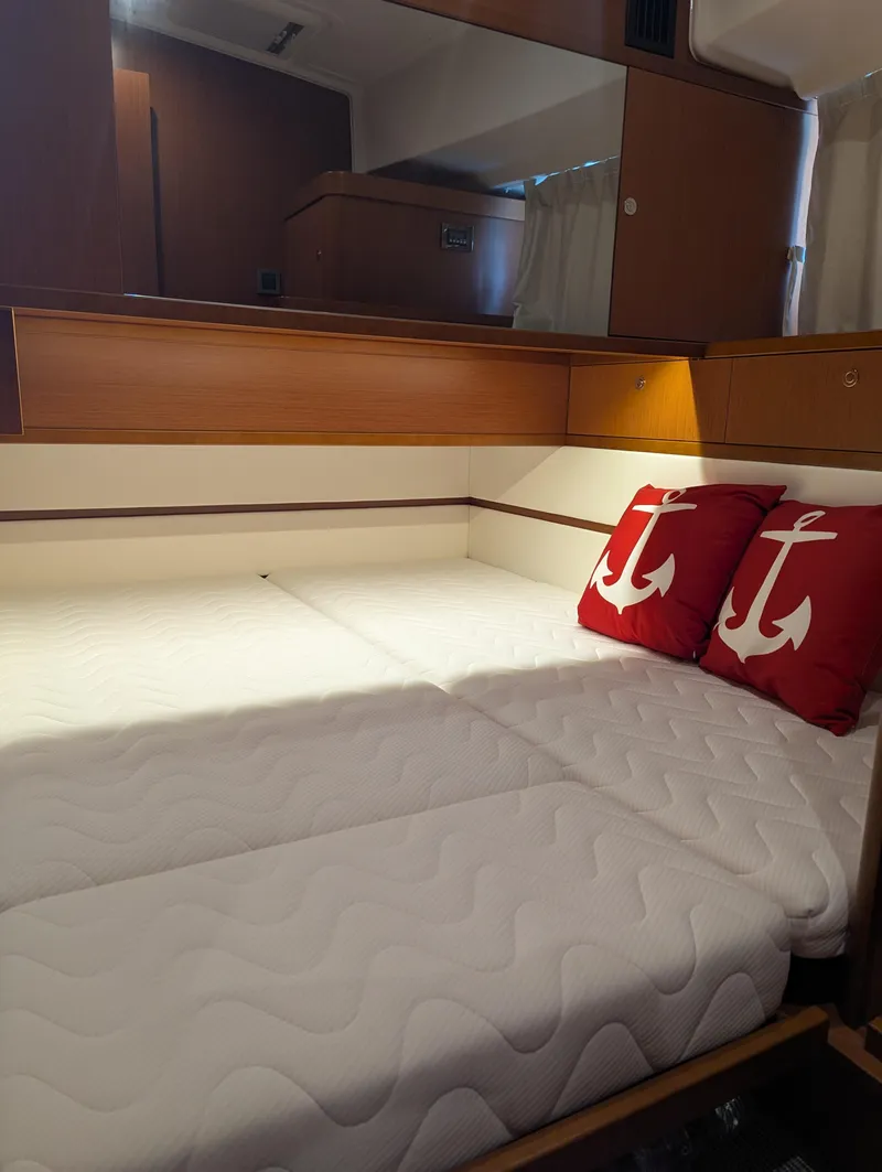 Slide: The Image of 2019 Beneteau Swift Trawler 44 cabin with twin beds and anchor-themed pillows. - 45