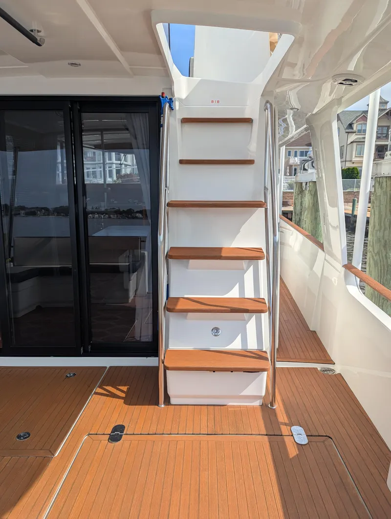Slide: The Image of Staircase on 2019 Beneteau Swift Trawler 44 with wooden steps and sliding glass doors. - 8
