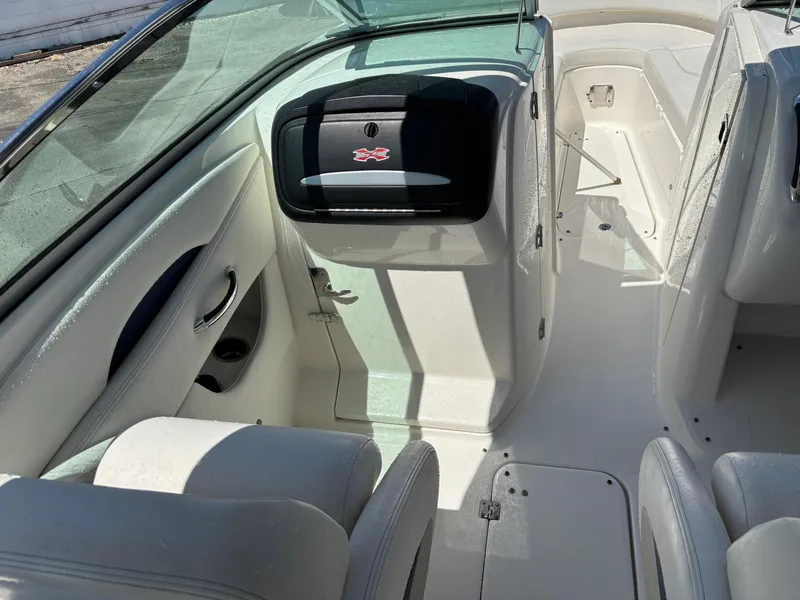 Slide: The Image of Interior view of a 2012 Chaparral 287 SSX boat, featuring white seating and storage compartments. - 11