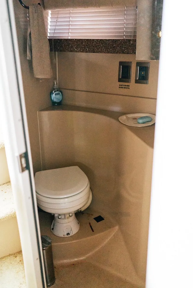 Slide: The Image of 2001 Cruisers Yachts 3075 Express bathroom with toilet, soap, and towel. - 13