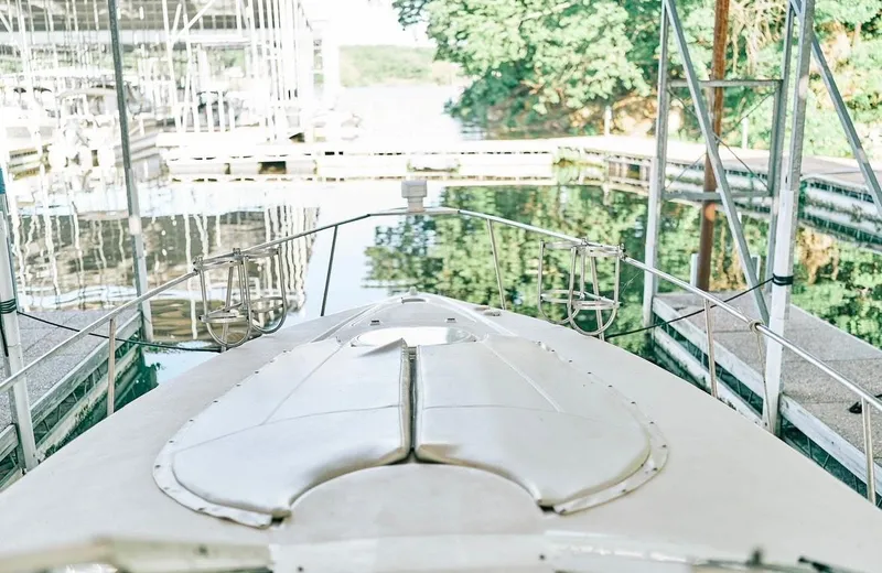 Slide: The Image of 2001 Cruisers Yachts 3075 Express docked at marina, surrounded by calm water and greenery. - 14