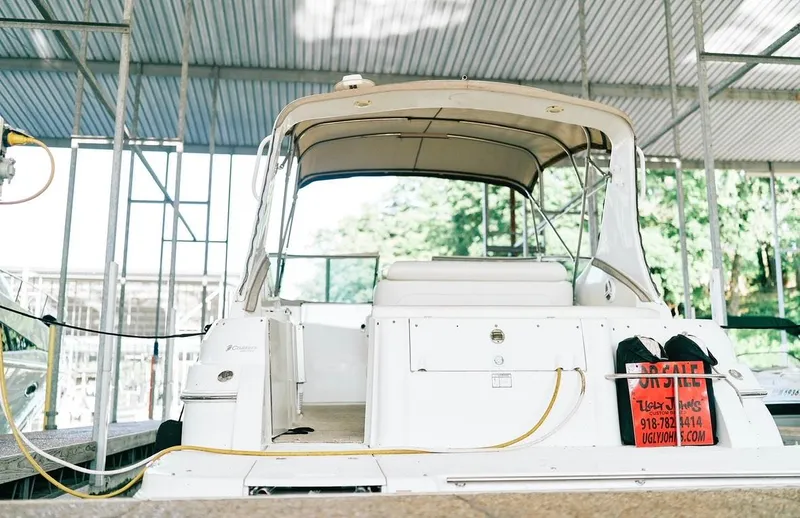 Slide: The Image of 2001 Cruisers Yachts 3075 Express docked, rear view with "For Sale" sign. - 20