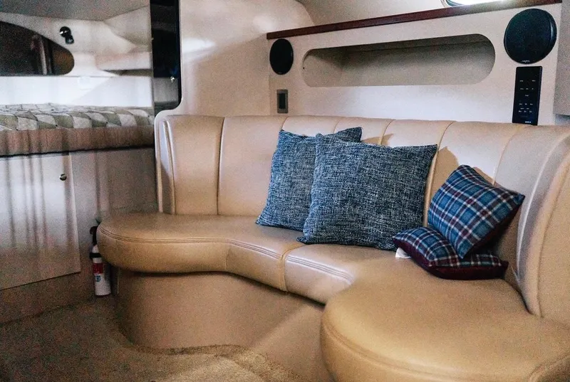 Slide: The Image of Interior of 2001 Cruisers Yachts 3075 Express with beige seating and decorative pillows. - 9
