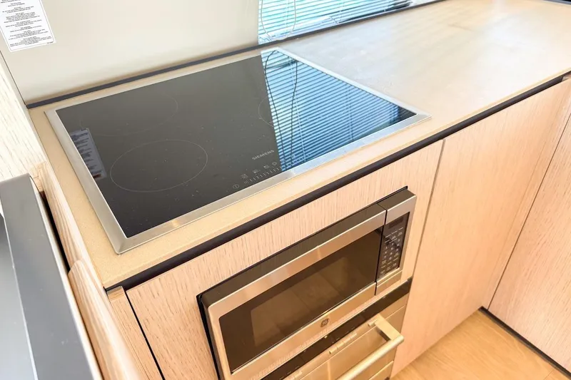 Slide: The Image of Modern kitchen in 2024 Ferretti Yachts 580 with sleek cooktop and microwave. - 23