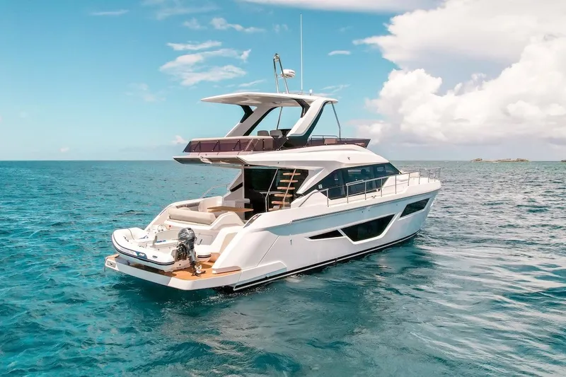 Slide: The Image of 2024 Ferretti Yachts 580 cruising on clear blue ocean under a bright sky. - 4