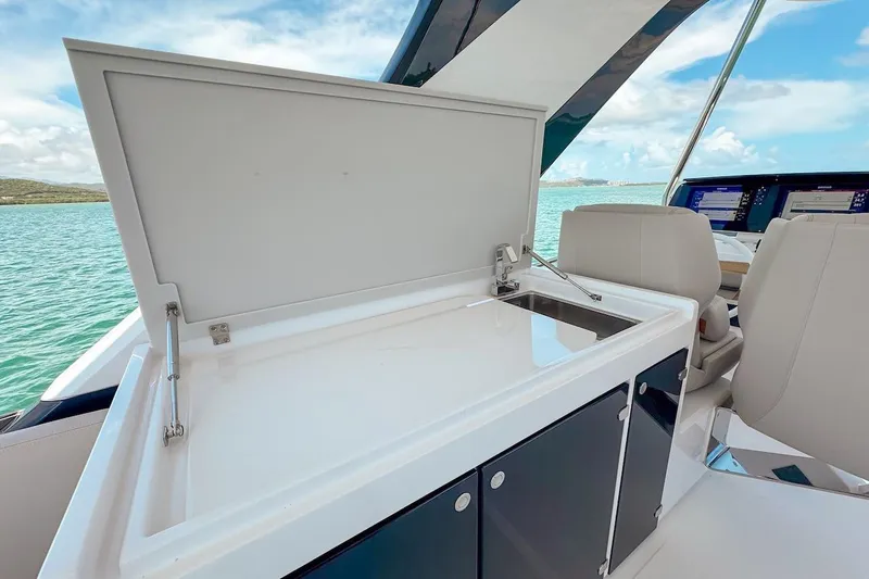 Slide: The Image of 2024 Ferretti Yachts 580 interior with open cabinet and sink, overlooking serene waters. - 51