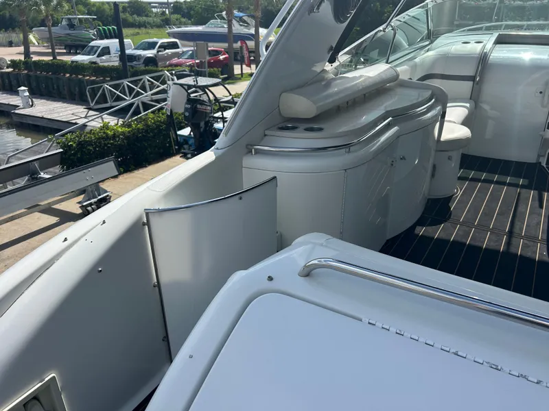 Slide: The Image of 2004 Formula 400 SS boat interior with seating and storage, docked near vehicles and greenery. - 11