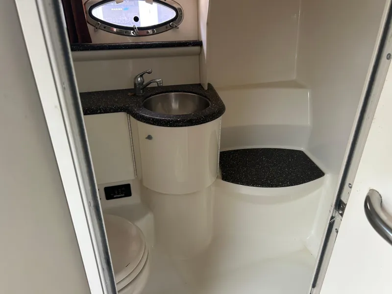 Slide: The Image of 2004 Formula 400 SS boat bathroom with sink, toilet, and porthole window. - 38