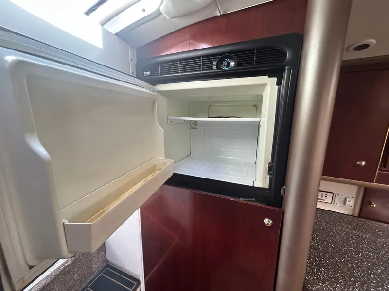 Slide: The Image of Open refrigerator in 2004 Formula 400 SS boat interior, featuring wooden cabinetry. - 40