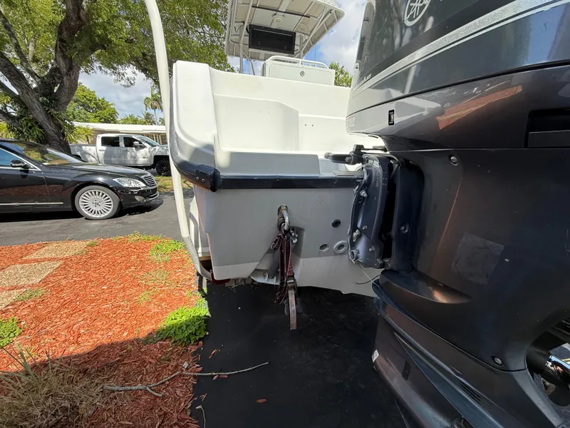 Slide: The Image of 2005 Boston Whaler 260 Outrage boat with outboard motor, parked on driveway. - 18