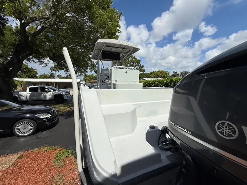 Slide: The Image of 2005 Boston Whaler 260 Outrage boat with Yamaha engine, parked outdoors under a tree. - 19