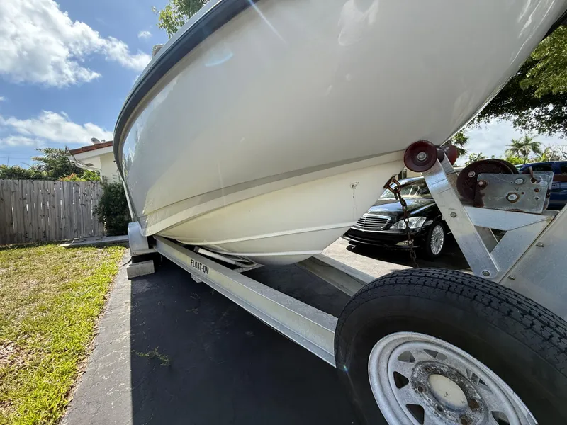 Slide: The Image of 2005 Boston Whaler 260 Outrage on trailer, parked outdoors under a clear sky. - 24