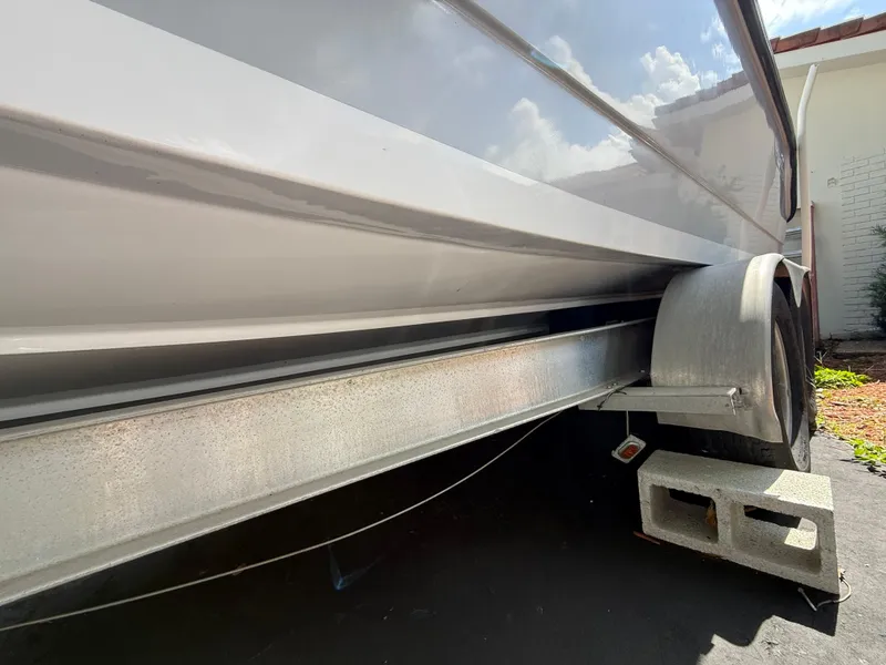 Slide: The Image of 2005 Boston Whaler 260 Outrage on trailer, side view under bright sunlight. - 26