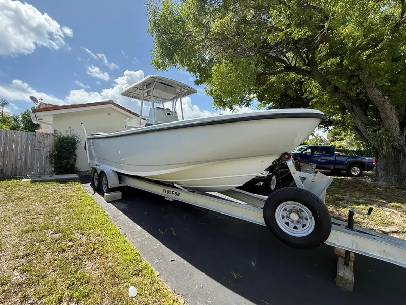 Slide: The Image of 2005 Boston Whaler 260 Outrage boat on trailer, parked in driveway under trees. - 3