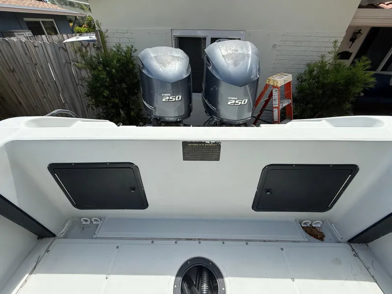 Slide: The Image of 2005 Boston Whaler 260 Outrage with twin Yamaha 250 engines, docked near a house. - 32