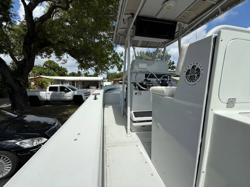 Slide: The Image of 2005 Boston Whaler 260 Outrage boat interior with steering console, parked outdoors. - 38