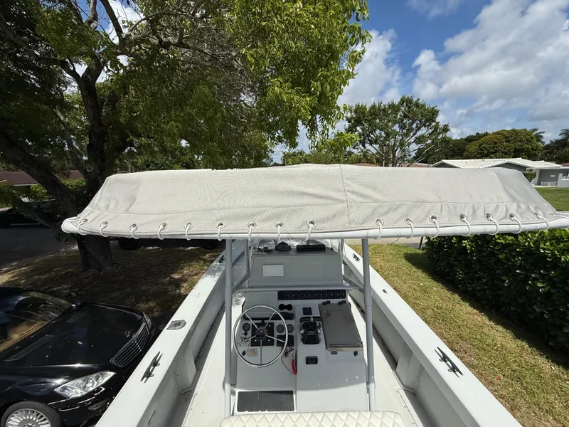 Slide: The Image of 2005 Boston Whaler 260 Outrage boat with canopy, parked under trees. - 41