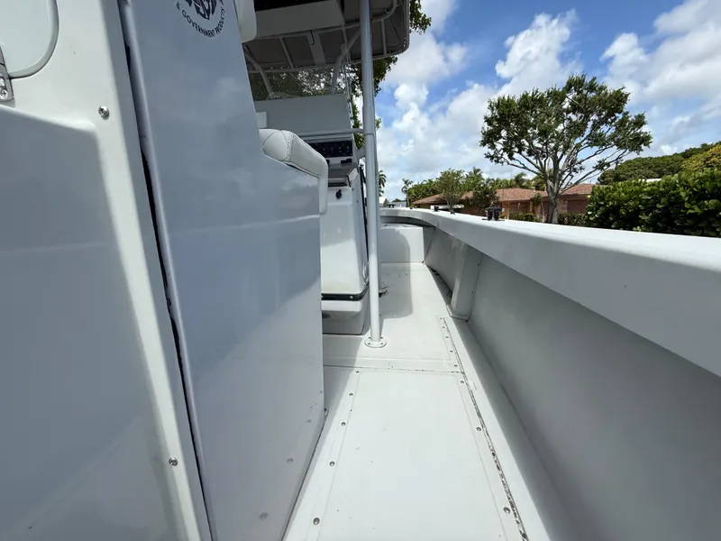 Slide: The Image of 2005 Boston Whaler 260 Outrage boat deck with clear sky and trees in background. - 43