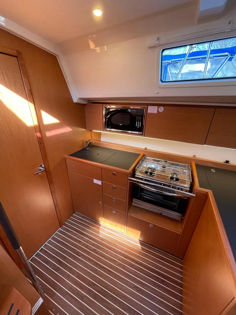Slide: The Image of Modern kitchen interior of 2023 Bavaria C42 yacht with wood finish and appliances. - 11