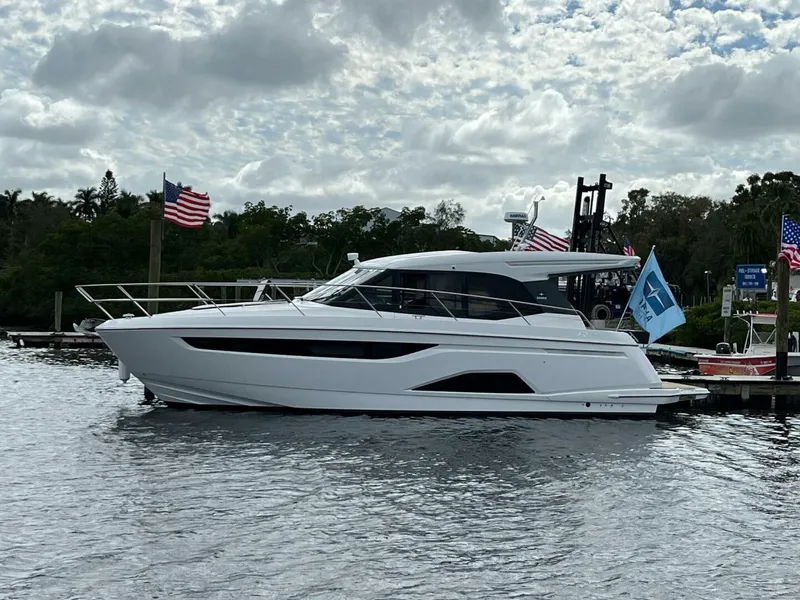 The Image of 2023 Bavaria R40 Coupe yacht docked, surrounded by flags, under a cloudy sky. - 0