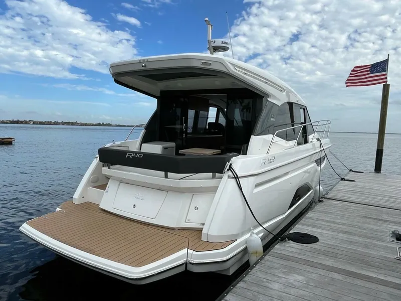 Slide: The Image of 2023 Bavaria R40 Coupe yacht docked by a pier with an American flag. - 3
