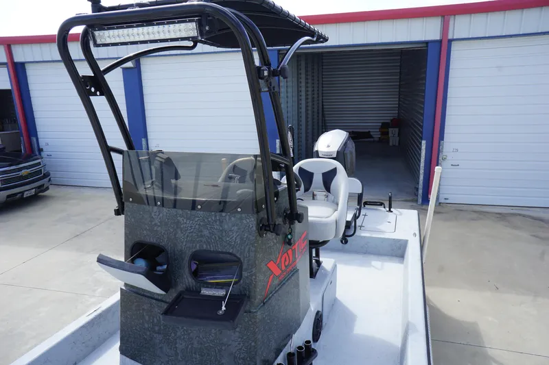 Slide: The Image of 2015 El Pescador 24 CAT boat in storage, featuring a center console and seating. - 10