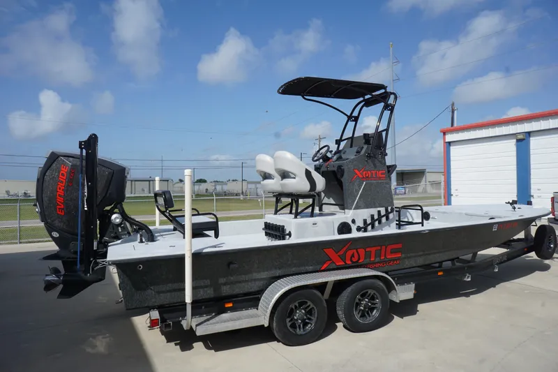 Slide: The Image of 2015 El Pescador 24 CAT boat with Evinrude engine, parked on a trailer. - 2
