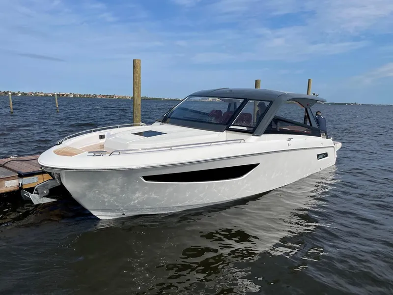 Slide: The Image of 2023 Bavaria Vida 33 boat docked on calm water under a clear blue sky. - 2