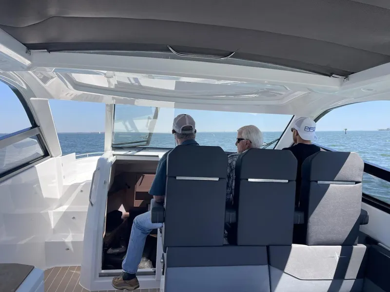 Slide: The Image of Three people seated inside a 2023 Bavaria Vida 33 boat, enjoying a scenic ocean view. - 20