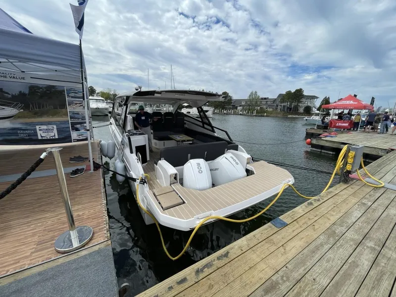 Slide: The Image of 2023 Bavaria Vida 33 motorboat docked at marina, showcasing sleek design and powerful engines. - 5