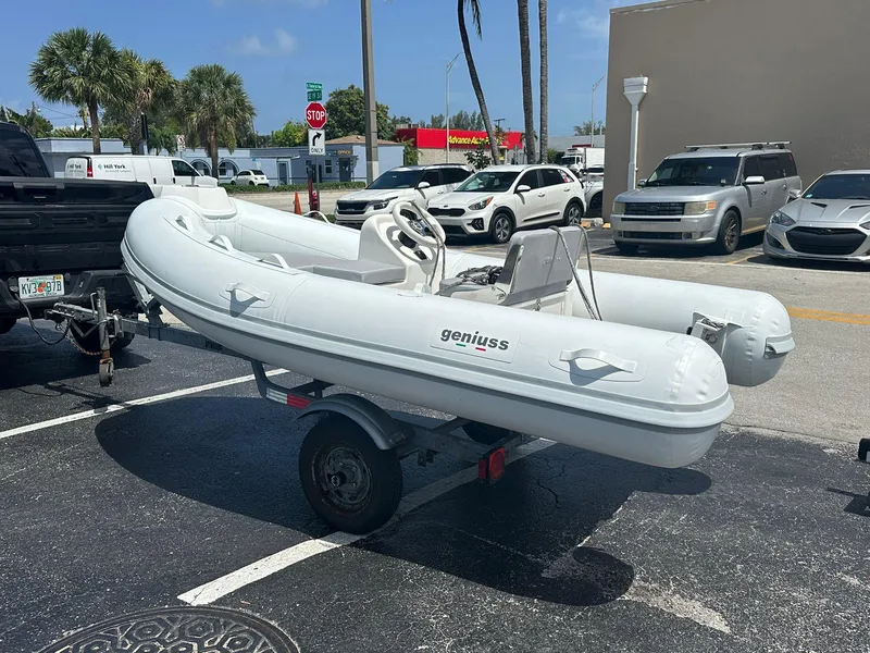 Slide: The Image of Inflatable Geniuss 380 HTS boat on trailer, parked in sunny lot, 2022 model. - 15
