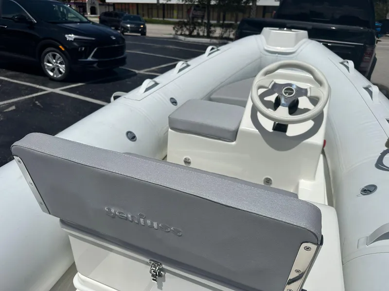 Slide: The Image of 2022 Geniuss 380 HTS inflatable boat interior with steering wheel in parking lot. - 18