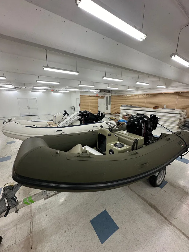 Slide: The Image of 2022 Geniuss 380 HTS inflatable boats in a well-lit showroom. - 2
