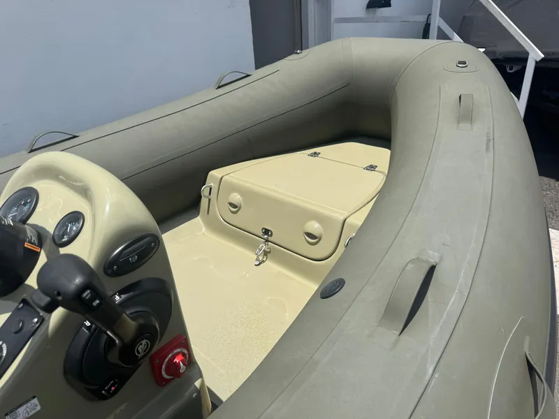 Slide: The Image of 2022 Geniuss 380 HTS inflatable boat interior with steering console and storage compartment. - 4