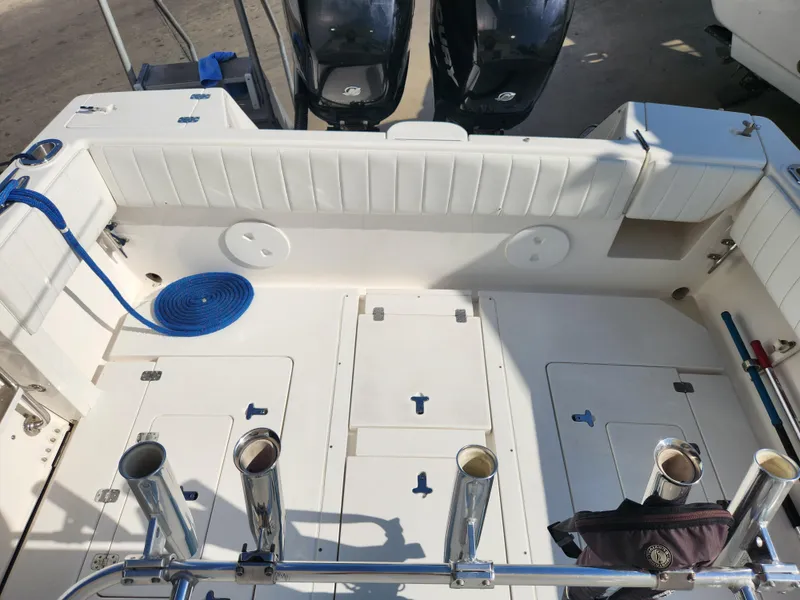 Slide: The Image of 2008 Intrepid 323 Cuddy boat deck with fishing rod holders and blue rope. - 15