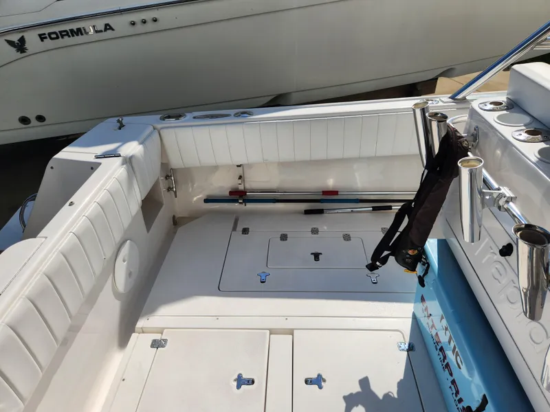 Slide: The Image of 2008 Intrepid 323 Cuddy boat interior with white seating and storage compartments. - 17