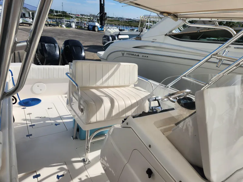 Slide: The Image of 2008 Intrepid 323 Cuddy boat interior with seating and controls, docked at marina. - 27