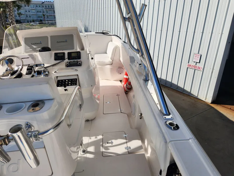 Slide: The Image of 2008 Intrepid 323 Cuddy boat interior with Garmin navigation, docked near a metal building. - 35