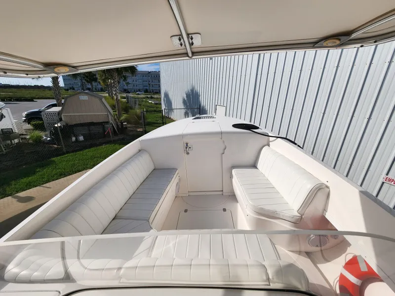 Slide: The Image of 2008 Intrepid 323 Cuddy boat interior with white seating and outdoor setting. - 36