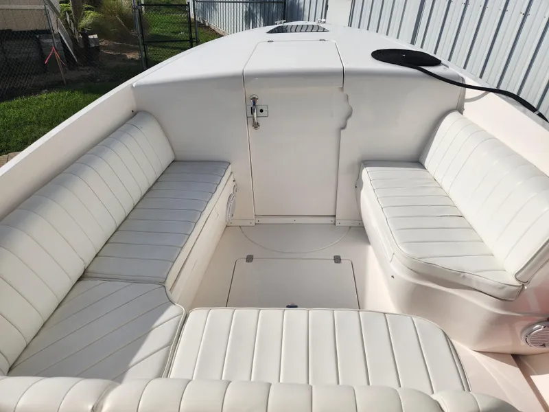 Slide: The Image of 2008 Intrepid 323 Cuddy boat interior with white cushioned seating. - 37