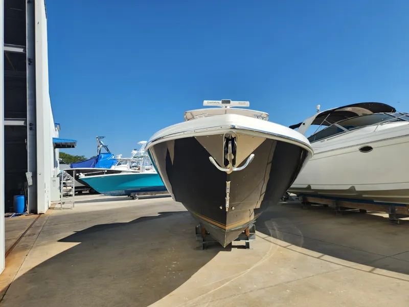 Slide: The Image of 2008 Intrepid 323 Cuddy boat in a marina, clear blue sky background. - 4