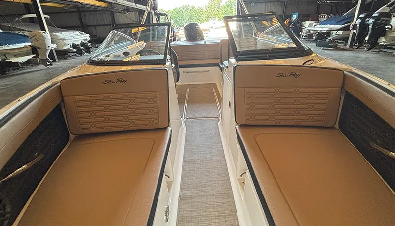 Slide: The Image of 2025 Sea Ray SPX 190 Outboard interior with tan seating in a boat storage facility. - 5