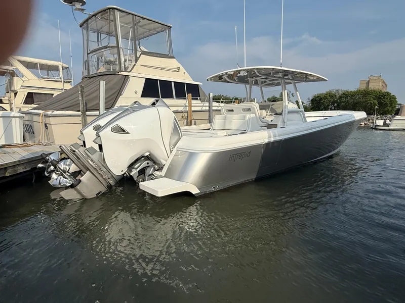 Slide: The Image of 2018 Intrepid 375 Open boat docked in marina, featuring sleek design and powerful engines. - 1