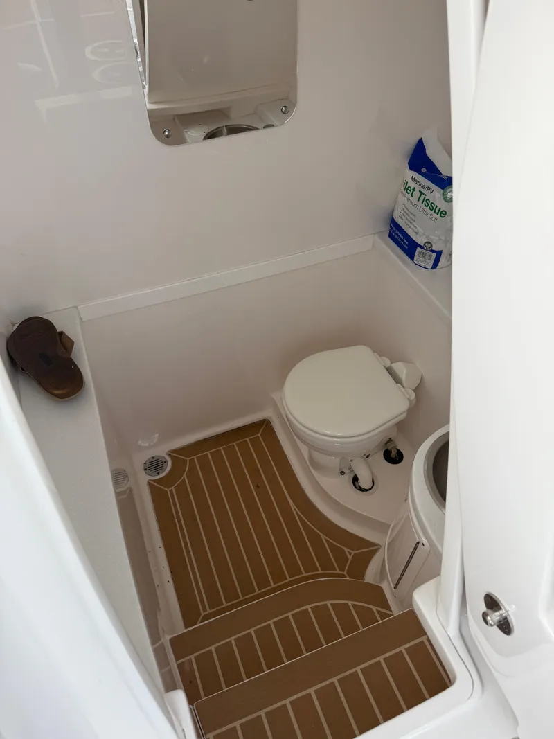 Slide: The Image of Compact marine bathroom in a 2018 Intrepid 375 Open boat, featuring a toilet and wooden floor. - 13