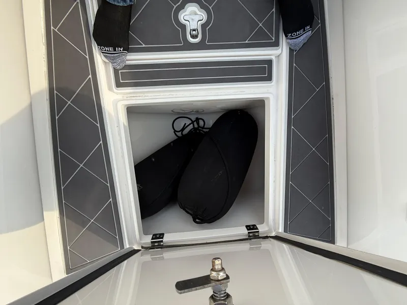 Slide: The Image of Open storage compartment on 2018 Intrepid 375 Open boat with black bags inside. - 17