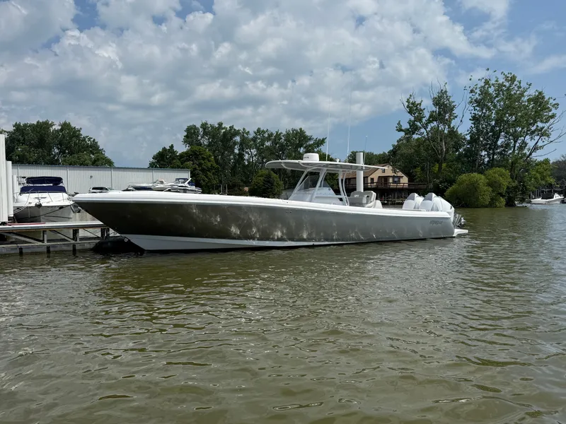 Slide: The Image of 2018 Intrepid 375 Open boat docked on a calm river under a cloudy sky. - 27