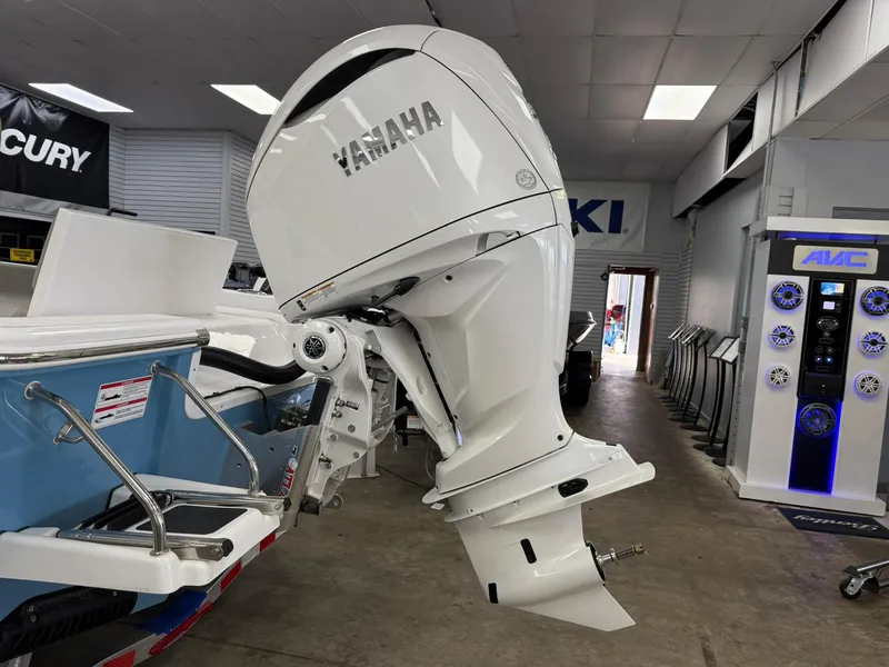 Slide: The Image of 2025 Sportsman Masters 247OE Bay Boat with Yamaha outboard motor in showroom. - 2