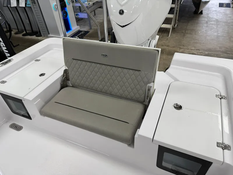 Slide: The Image of 2025 Sportsman Masters 247OE Bay Boat interior with cushioned seating and storage compartments. - 5