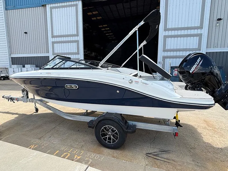 Slide: The Image of 2025 Sea Ray SPX 190 Outboard boat on trailer, parked outside a warehouse. - 4
