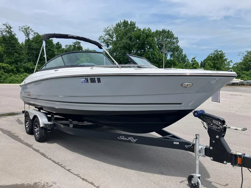 The Image of 2022 Monterey 224FS boat on trailer, parked outdoors with trees in background. - 0